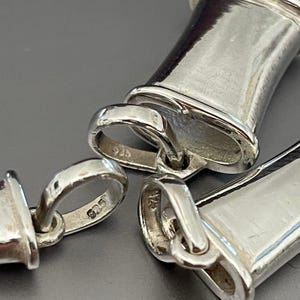 Close-up of the 925 sterling silver hallmarks on the breathing pendants.