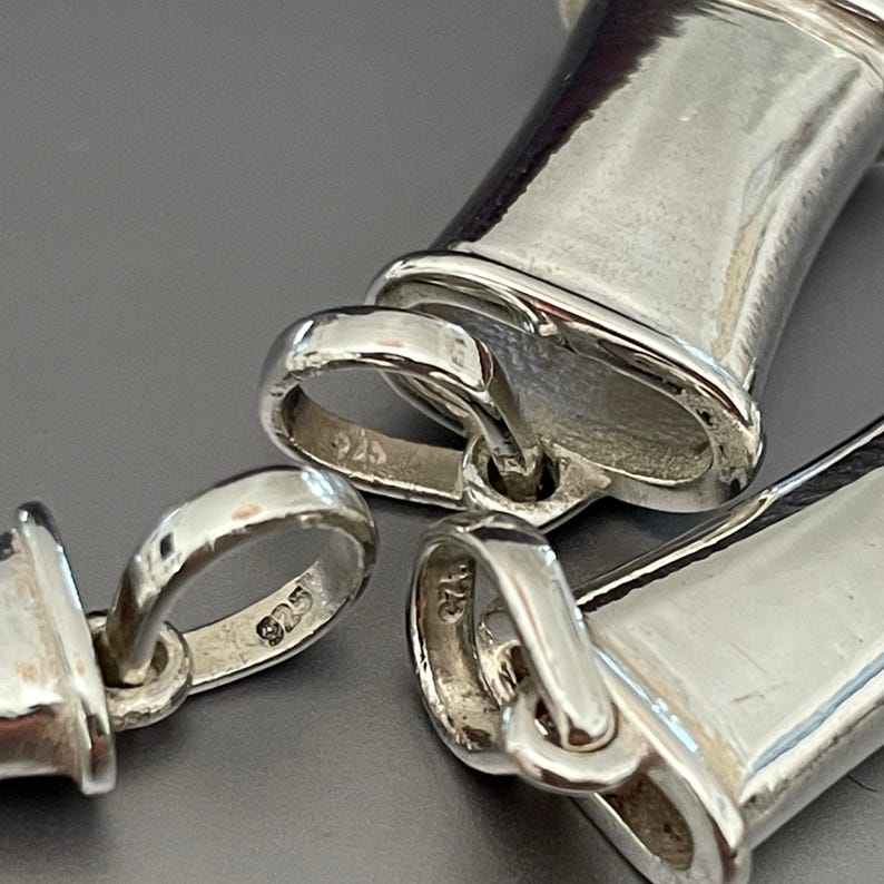 Close-up of the 925 sterling silver hallmarks on the breathing pendants.