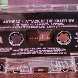 May include: Clear cassette tape of Anthrax's "Attack of the Killer B's" album. The cassette features the album title, tracklist, and Island Records logo. Side B details include the catalog number and a total running time of 21:37.