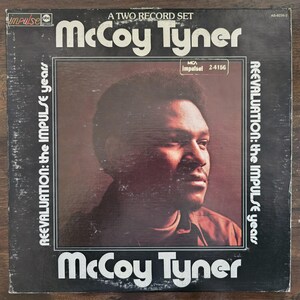 Może przedstawiać: Vintage okładka albumu winylowego dla "McCoy Tyner: Reevaluation: The Impulse Years". Okładka przedstawia portret McCoy Tynera w brązowo-czarnej kolorystyce, z tytułem albumu i nazwiskiem artysty w białym tekście.