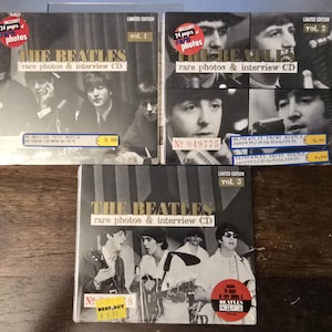 May include: Three CD cases featuring The Beatles, labeled as "rare photos & interview CD." Each case has a black and white image of the band members. The cases are marked as "Limited Edition" and include "24 pages of photos."