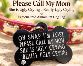 May include: A black bone-shaped aluminum dog tag featuring the engraved text: OH SNAP I'M LOST PLEASE CALL MY MOM SHE IS UGLY CRYING ...REALLY UGLY CRYING, with a small paw print icon at the bottom. The tag is attached to a pink collar with bone accents.