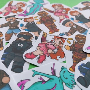 May include: A collection of colorful die-cut stickers featuring various cartoon characters. The stickers depict figures in action poses, including a mermaid, a person in a black uniform with the number 06, and other characters with weapons.