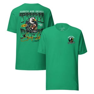 May include: Two green t-shirts with football-themed designs. One has a large graphic on the back with an eagle holding a football, the words "TUSH PUSH", and "Say Yes". The other has a smaller eagle and football graphic on the front with the word "Unstoppable".