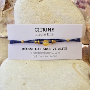 Könnte beinhalten: Ein blaues Armband aus Schnur mit goldenen Perlen und einem Citrin-Edelstein. Das Armband liegt auf einer weißen Karte mit dem Text "CITRINE Pierre fine RÉUSSITE-CHANCE-VITALITÉ ricochetcreation.etsy.com Fait main en France".