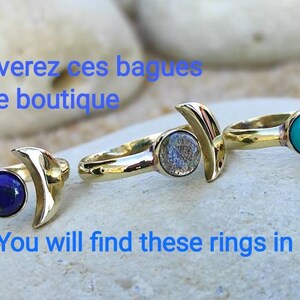 May include: Three gold rings with crescent moon designs. Each ring features a different gemstone: a blue lapis lazuli, a grey labradorite, and a turquoise stone.