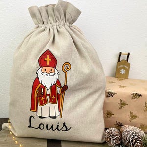 Personalisierter Nikolaussack mit klassischem Nikolaus-Motiv und Name Louis – nachhaltiger Weihnachtssack aus Leinen als Nikolausgeschenk.