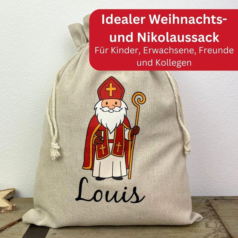 May include: A beige drawstring gift bag featuring a cartoon illustration of Saint Nicholas in red and white robes, holding a staff. The name "Louis" is printed in black script below the illustration. Text in a red banner reads "Ideal Christmas and St. Nicholas Sack."