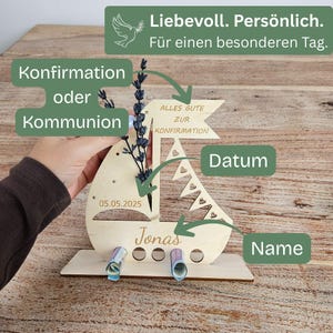 K&ouml;nnte beinhalten: Ein Geschenkhalter in Form eines Holzsegelbootes mit dem Namen "Jonas" und dem Datum "05.05.2025" eingraviert. Das Segelboot hat eine Flagge mit der Aufschrift "Alles Gute zur Konfirmation". Der Text "Konfirmation oder Kommunion" ist ebenfalls sichtbar.