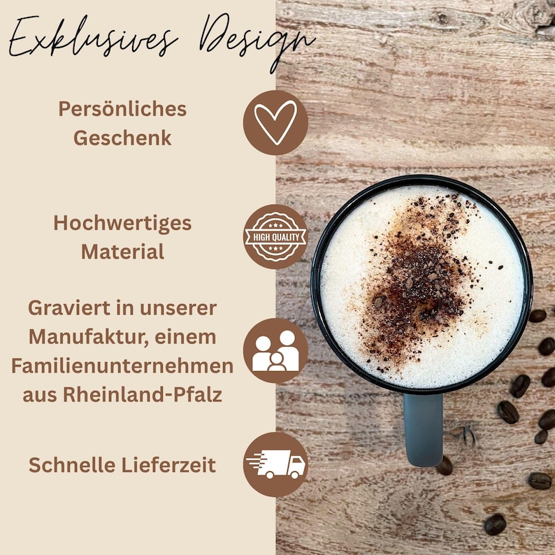 Op de afbeelding: Een zwarte koffiemok met een grijze handgreep, gevuld met een cappuccino gegarneerd met cacaopoeder. De afbeelding bevat de tekst "Exklusives Design", "Pers&ouml;nliches Geschenk" en "Hochwertiges Material".