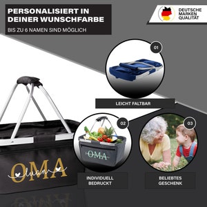 May include: A black and gray shopping basket with a silver handle. The basket is personalized with the word "OMA" in gold lettering. The basket is shown with a variety of fruits and vegetables inside. The text "INDIVIDUELL BEDRUCKT" is below the basket.