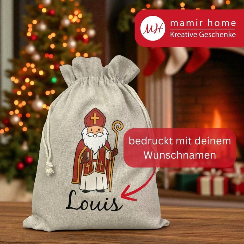 May include: A beige drawstring gift bag featuring a cartoon illustration of a saint in red and white robes, holding a staff. The name "Louis" is printed in black script below the illustration. The bag has a festive theme.