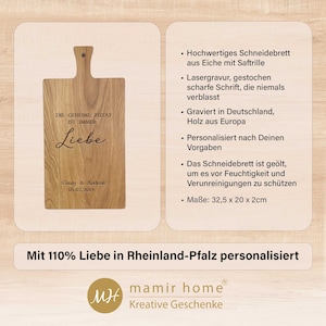 Op de afbeelding: Gepersonaliseerd houten snijplank met de tekst "Die geheime Zutat ist immer Liebe" en de datum "05.07.2014". De plank is gemaakt van eikenhout en heeft een sapgroef. Het meet 32,5 cm x 20 cm x 2 cm.