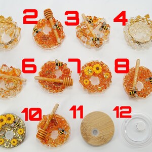 May include: A collection of twelve decorative resin items, including lids and coasters. The coasters feature honey dippers, bees, and sunflower designs. The items are in shades of orange, yellow, and clear.