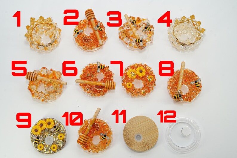 May include: A collection of twelve decorative resin items, including lids and coasters. The coasters feature honey dippers, bees, and sunflower designs. The items are in shades of orange, yellow, and clear.