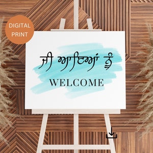 May include: A welcome sign with a blue watercolour background. The sign says "Welcome" in English and "ਆ ਗਈਆਂ ਹੋ" in Punjabi.