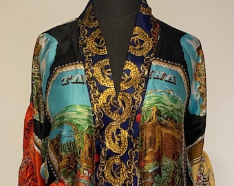 May include: A long, open-front robe featuring a vibrant patchwork design of various city landmarks, including London and Taormina, combined with a central vertical panel of gold chain-link patterns on a dark blue background and colorful silk accents.