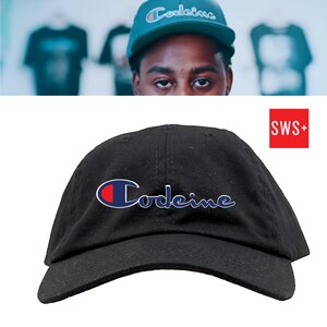 May include: Black baseball cap with the word "Codeine" in a white, blue, and red design. The cap has a curved brim and a classic six-panel construction. The hat is made of a durable fabric.
