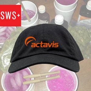 May include: Black baseball cap with an orange logo that says "Actavis" on the front.