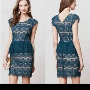 Puede incluir: Un vestido de encaje azul teal con cintura peplum y mangas cortas. El vestido tiene un delicado patr&oacute;n floral y una silueta ajustada.