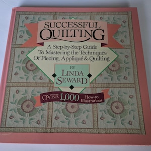 May include: A hardcover book titled "Successful Quilting" with a floral quilt pattern on the cover. The book includes the text "A Step-by-Step Guide To Mastering the Techniques Of Piecing, Appliqué & Quilting" and "Over 1,000 How-to Illustrations."