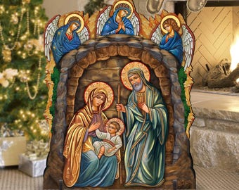 Può includere: Una scena della natività natalizia in legno con uno sfondo marrone simile alla pietra. La scena rappresenta Maria, Giuseppe e il bambino Gesù, insieme a due angeli con le ali. Le figure sono dipinte in uno stile tradizionale con colori vivaci.
