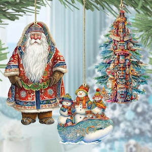 May include: Three Christmas ornaments featuring a red and blue Santa Claus, a group of snowmen riding a whale, and a blue Christmas tree with a totem pole design.