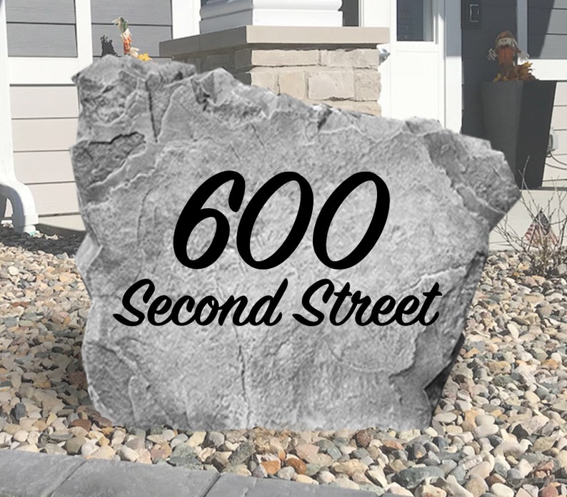 May include: A gray concrete rock with the address "600 Second Street" painted in black.