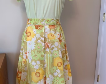 May include: A yellow, green and orange floral print skirt with a pleated design. The skirt is knee-length and has a fitted waist.