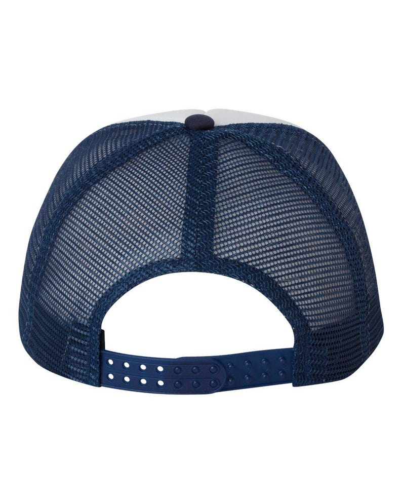 May include: A navy blue trucker hat with a white front panel and a mesh back. The hat features a snapback closure for adjustable sizing. The crown has a button on top. This hat is a classic accessory for casual wear.