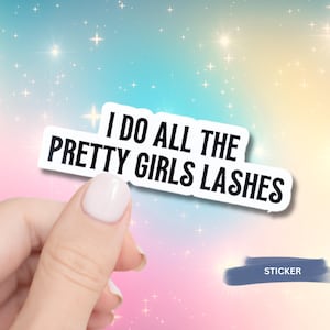 May include: A white sticker with black text that reads "I DO ALL THE PRETTY GIRLS LASHES" is held by a hand with a light pink nail polish. The background is a gradient of pastel colors with sparkling stars.
