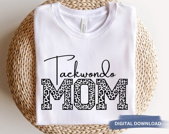 May include: White t-shirt with the text "Taekwondo MOM" in black. The "MOM" is in large, bold letters with a leopard print pattern.