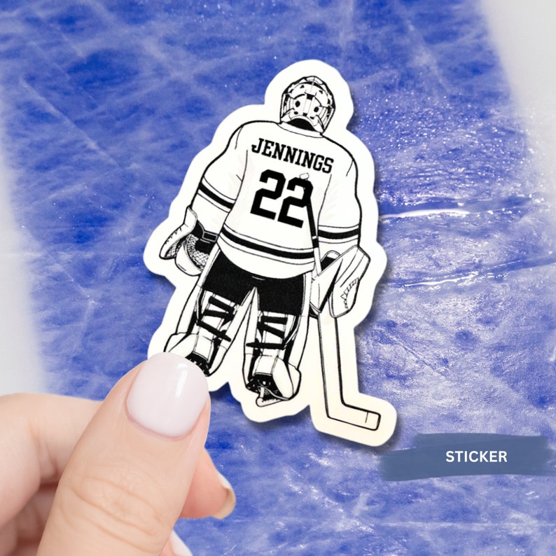 May include: Black and white sticker of a hockey goalie in a standing position, wearing a jersey with the name "Jennings" and the number "22" on the back. The goalie is holding a hockey stick and wearing a helmet and pads.