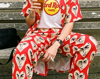 Pantaloni a gamba larga con faccina a cuore surreale, pantaloni da casa rossi in stile Weirdcore, streetwear alternativo ed eccentrico