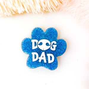 May include: Blue glitter paw print with the words "Dog Dad" in white lettering.