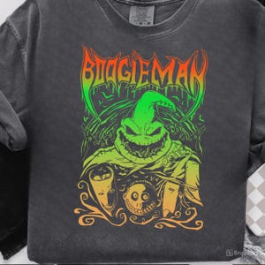 Puede incluir: Sudadera gris oscuro con un gráfico colorido del personaje Oogie Boogie de The Nightmare Before Christmas. El diseño incluye la palabra "BOOGIEMAN" en una fuente en forma de llama, con tonos verdes, naranjas y amarillos.
