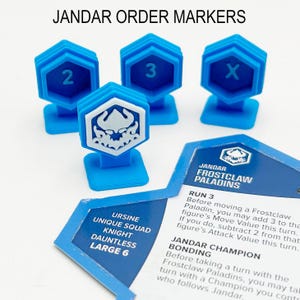 Könnte beinhalten: Blaue Plastik-Ordnungsmarker für ein Brettspiel. Die Marker sind mit 2, 3 und X nummeriert. Es gibt auch einen Marker mit einem weißen Totenkopf und Flammenmuster. Das Bild zeigt auch eine Karte für die Jandar Frostclaw Paladins mit dem Text "Run 3" und "Jandar Champion Bonding".