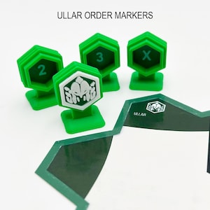 Könnte beinhalten: Grüne Plastik-Ordnungsmarker für ein Brettspiel. Die Marker sind mit 2, 3 und X nummeriert. Ein Marker hat ein weißes Symbol einer Kreatur mit einer Krone.