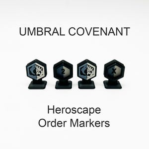 May include: Four black hexagonal Heroscape order markers with stands. Two markers feature a split-tone face with a stylized crown icon, while the others display the numbers 2 and X. The text UMBRAL COVENANT and Heroscape Order Markers is visible.