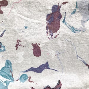 May include: Abstract art print featuring a white background with splashes of blue, purple, and brown paint.