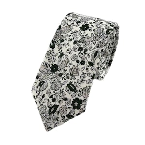 May include: A white necktie with a green floral pattern.