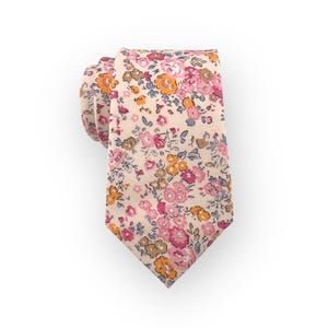Puede incluir: Una corbata de color crema con un estampado floral en tonos rosa, naranja y gris.