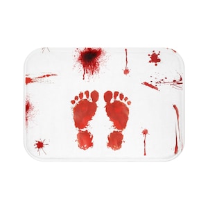 Peut inclure: Un tapis de bain blanc avec des éclaboussures de sang rouge et deux empreintes de pieds sanglantes.