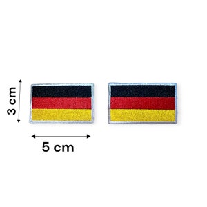 May include: Two embroidered German flag patches, each measuring 5 cm wide and 3 cm high. The flags are black, red, and gold.