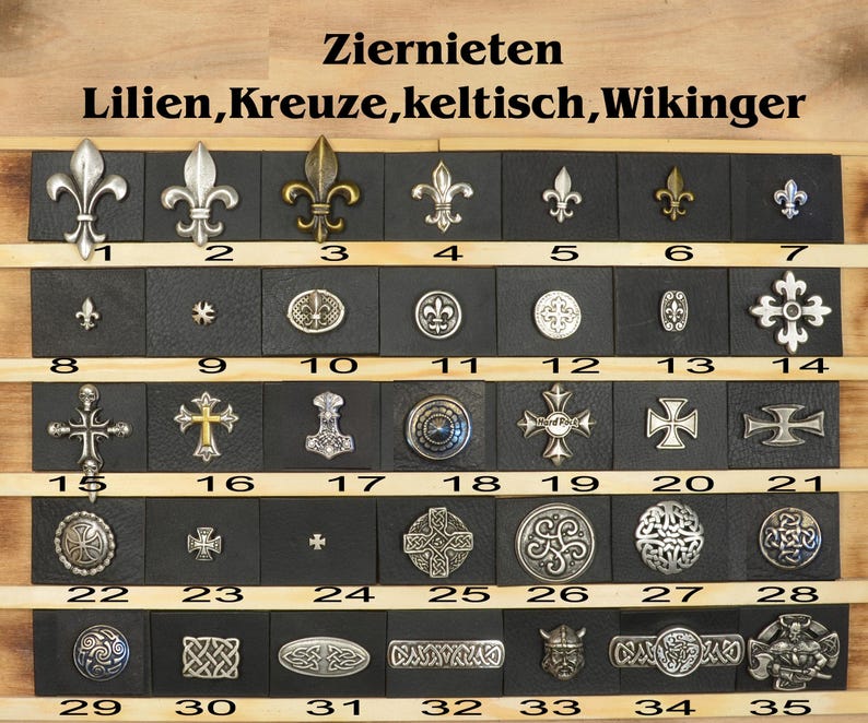 May include: A collection of 35 metal decorative rivets in various designs, including lilies, crosses, Celtic knots, and Viking symbols. The rivets are arranged in rows on a black background with white numbers indicating their position.