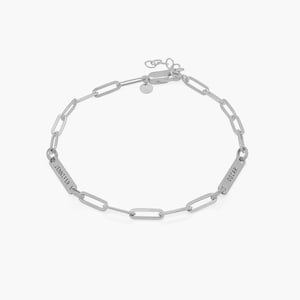 Peut inclure: Bracelet en chaîne argent avec deux plaques de nom personnalisées, l'une portant l'inscription "Jennifer" et l'autre "Oscar".