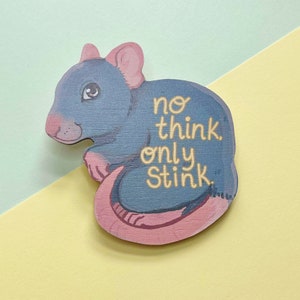 Peut inclure: Un rat en bois bleu et rose avec le texte "no think only stink" écrit dessus.