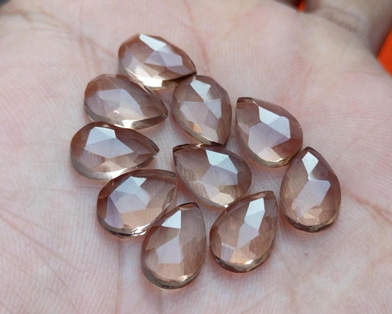Pu&ograve; includere: Una collezione di dieci perle di pietra preziosa sfaccettate a forma di lacrima di colore marrone chiaro. Le perle sono traslucide e hanno una finitura liscia e lucida.