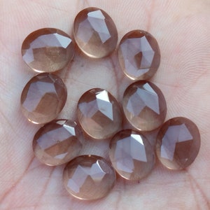 May include: Ten faceted, translucent, light brown gemstones. The stones are oval shaped and have a smooth, polished finish.