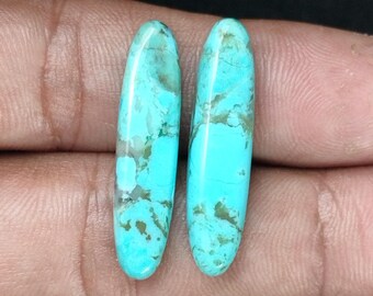 May include: Two oval-shaped turquoise cabochons with a light blue and green marbled pattern.